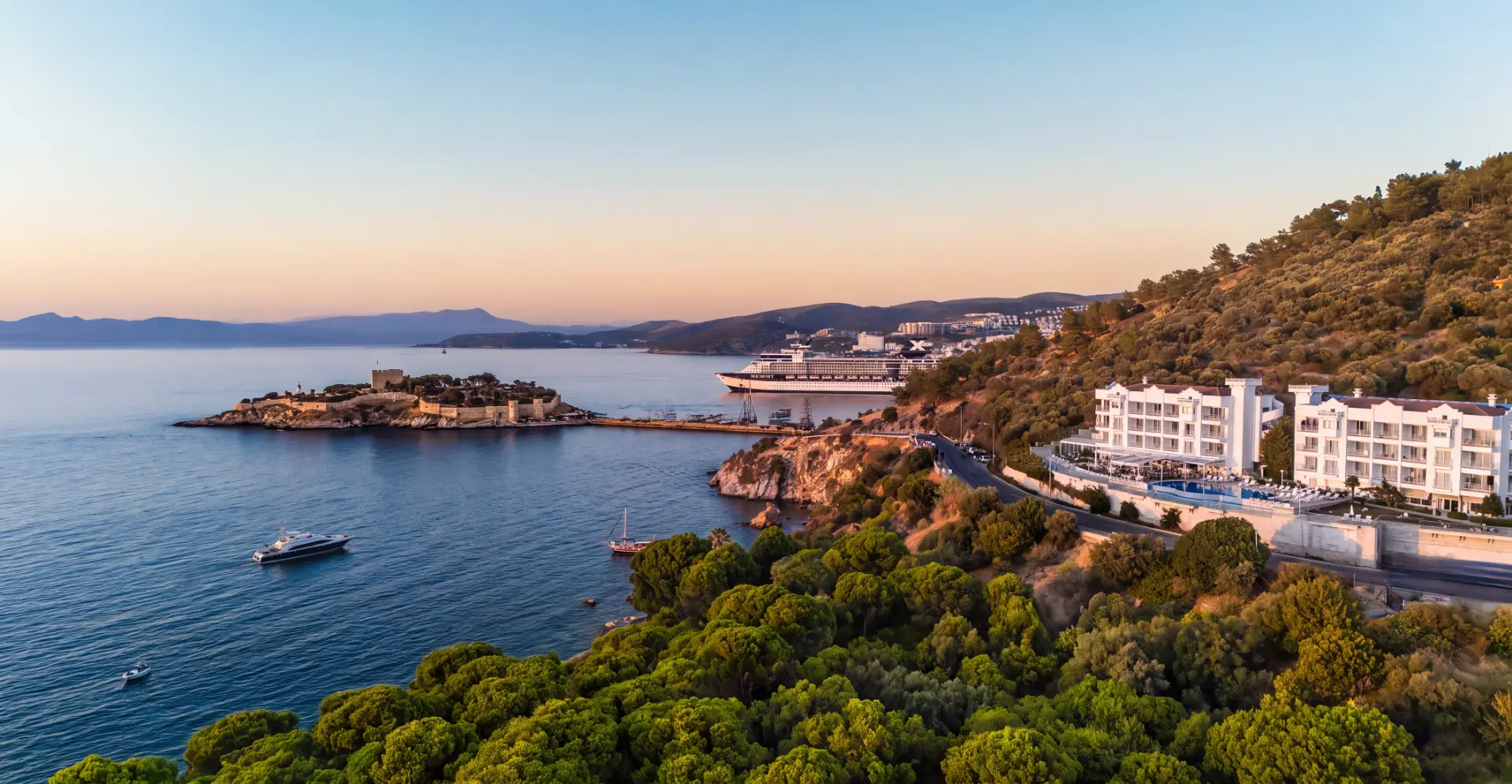 Gün batımında Kuşadası koyu, Güvercinada ve La Vista'nın havadan görünümü